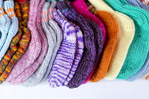 Una fila de calcetines multicolores de punto a mano para bebés Fotos De Stock