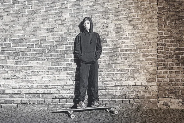 Noir et blanc pousse d'un adolescent garçon avec sweat à capuche debout sur un — Photo