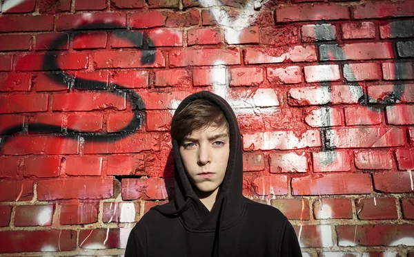 Retrato de un adolescente serio frente a un graffiti rojo Imagen De Stock