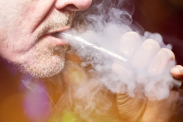 Primer plano retrato de un hombre fumando un cigarrillo electrónico — Foto de Stock