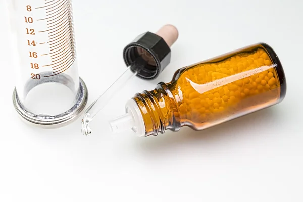 Fles met homeopathie bolletjes, spuit en Pipetteer — Stockfoto