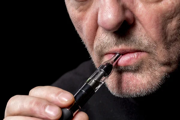 Крупным планом портрет человека, курящего электронную сигарету — стоковое фото