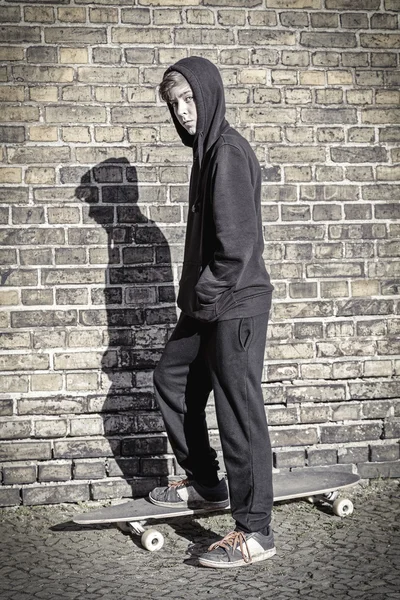 Adolescente com capuz de pé em uma prancha longa — Fotografia de Stock