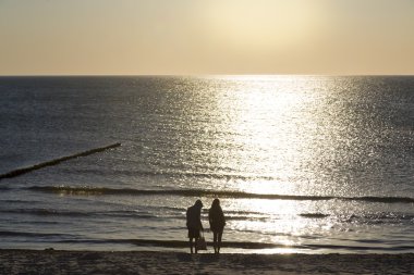 plajda iki kişiyle Okyanusu günbatımı