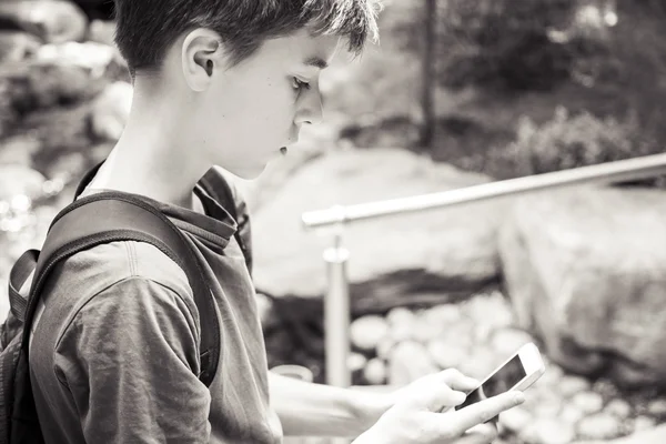 Adolescent garçon est à la recherche sur un téléphone intelligent — Photo