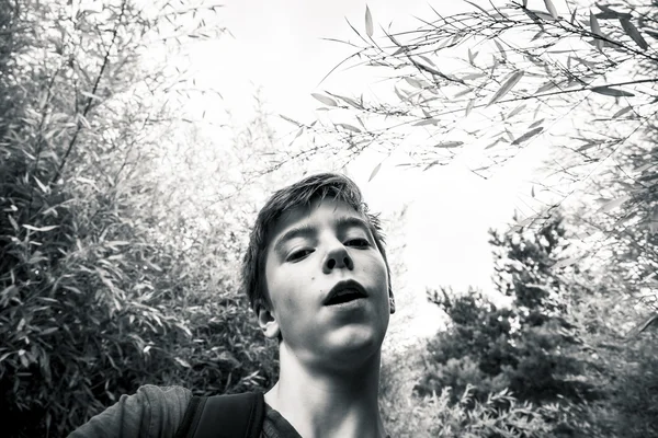 Tiro preto e branco de um adolescente em um jardim — Fotografia de Stock