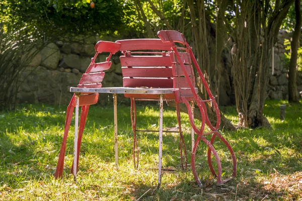 Tři staré, červený skládací židle, opřel se o stůl — Stock fotografie