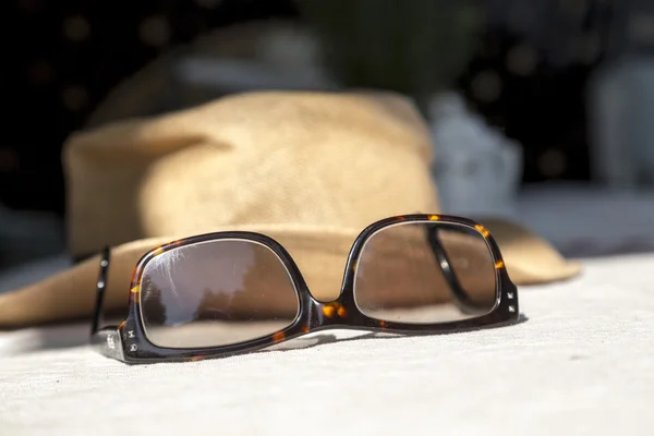 Nahaufnahme von Sonnenbrille und Strohhut — Stockfoto