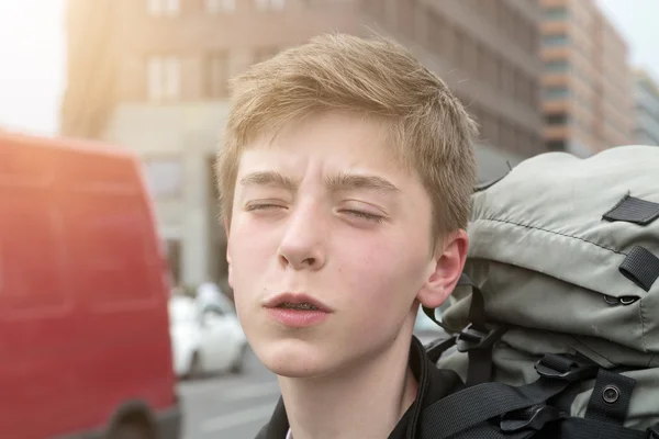 Portrait of a suffering teenage boy with heavy backpack — Stock Photo, Image