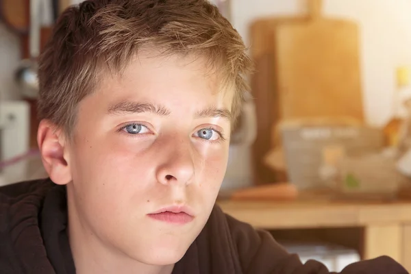 Retrato de un adolescente sentado en una cocina — Foto de Stock