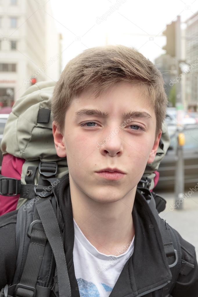 portrait of a teenage boy with heavy backpack