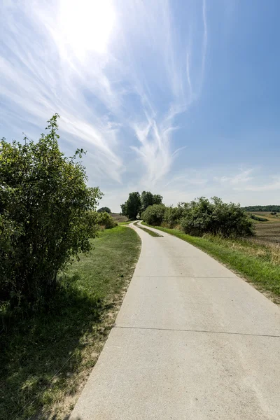 Small concrete road through fields in germany — Stock Photo, Image