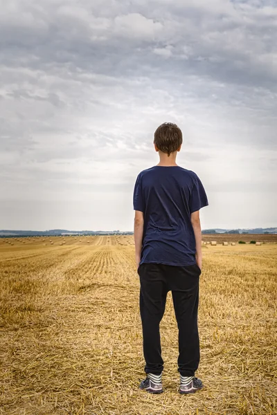 De achterkant van een tiener jongen op zoek naar het landschap — Stockfoto