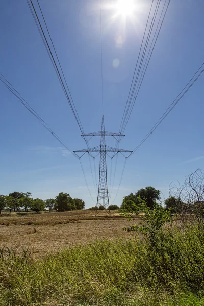 Strommast mit der Sonne davor — Stockfoto