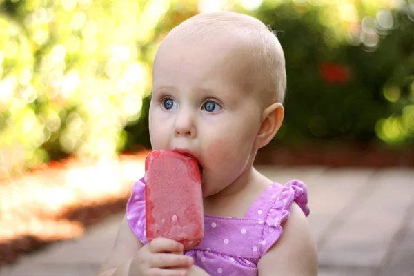 Bonito bebê menina comer congelado frutas picolé — Fotografia de Stock