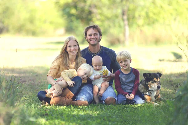 Família feliz de 5 pessoas e cachorro no jardim ensolarado — Fotografia de Stock