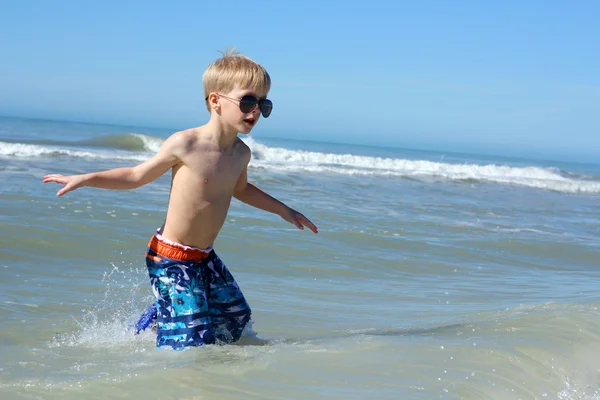 Jeune enfant marchant dans l'eau de l'océan — Photo