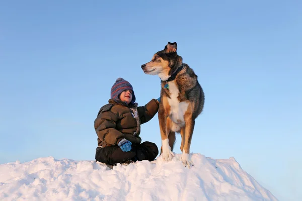 冬の雪で外ペット犬と遊ぶ若い子 — ストック写真