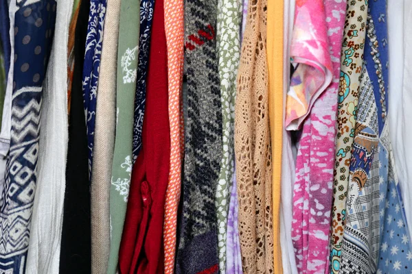Variedad de telas de ropa de colores colgando en el armario — Foto de Stock