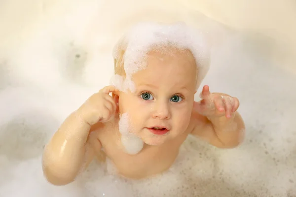 Baby omfattas i tvål i bubbelbad — Stockfoto