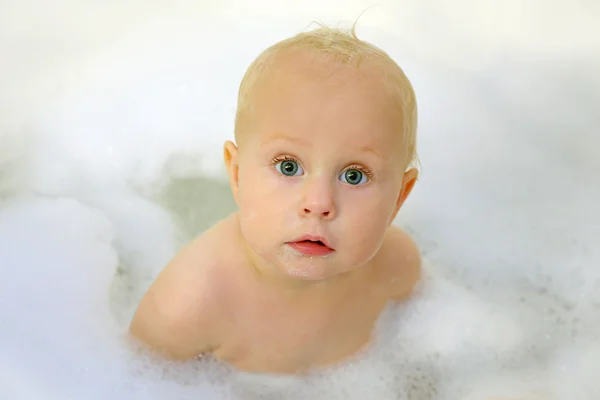 Söt Baby med stora blå ögon i bubbelbad — Stockfoto