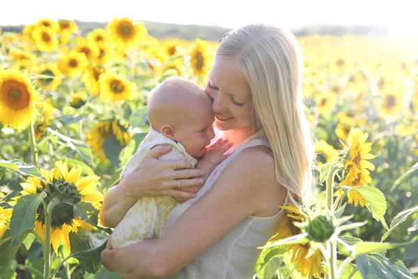 Happy Mother Hugging Baby Daughter in Flower Meadow — Stock Photo, Image