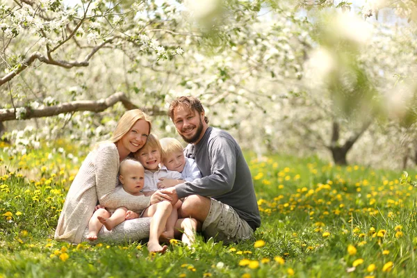 Familia feliz de cinco retratos en el prado de flores de primavera — Foto de Stock