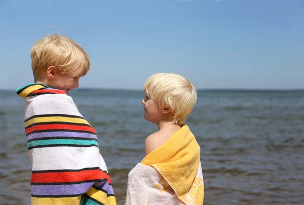 İki mutlu çocuk gülümseyen birbirimize plaj — Stok fotoğraf