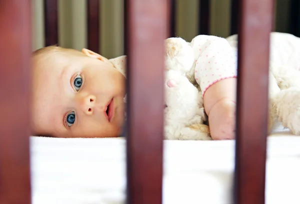 Tamamen uyanık bebek kız beşik içinde döşeme — Stok fotoğraf