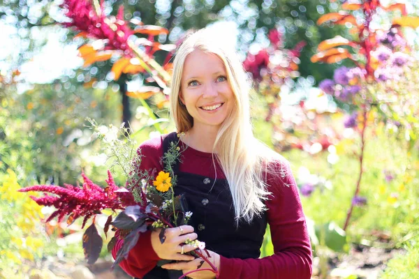 Vacker Glad Kvinnlig Trädgårdsmästare Ler När Hon Håller Blommor Ute — Stockfoto