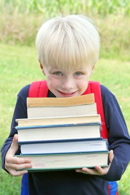 büyük ağır okul kitap taşıyan küçük bir çocuk