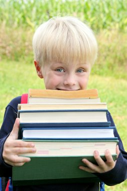büyük ağır okul kitap taşıyan küçük bir çocuk