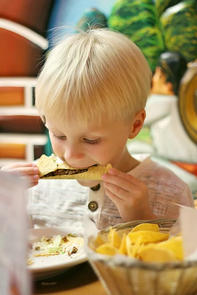 Niño pequeño comiendo tacos en restaurante mexicano — Foto de Stock