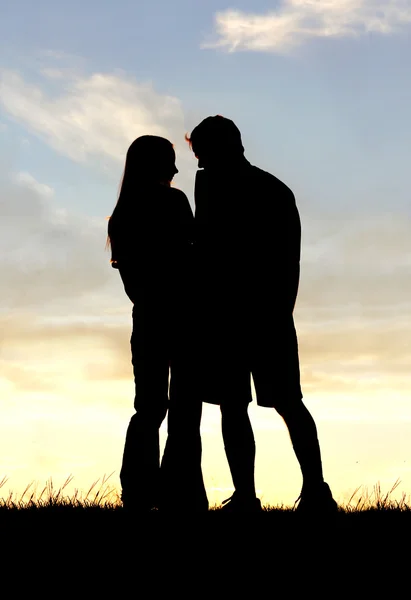 Силуэт влюбленной пары, держащейся за руки на закате — стоковое фото