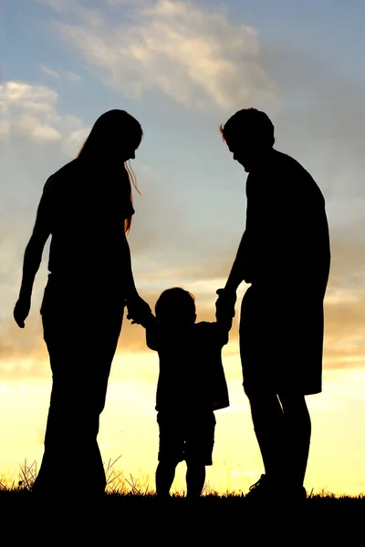 Caminhada em família na silhueta do pôr do sol — Fotografia de Stock