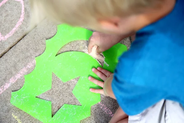 Jong kind tekening buiten met Sidewalk krijt — Stockfoto