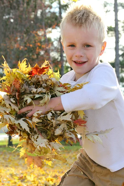 Joven niño corriendo y lanzando hojas de otoño —  Fotos de Stock