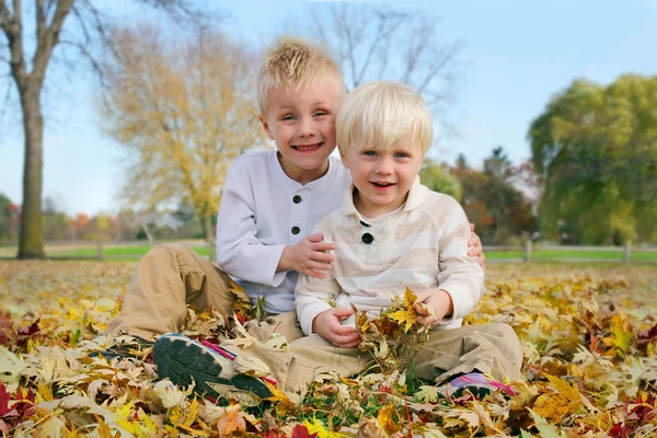 Portret jonge kinderen buiten in gevallen Autumn Leaves — Stockfoto