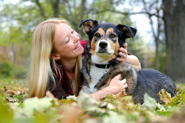 Relaksująca kobieta z psem Owczarek niemiecki na dzień jesieni — Zdjęcie stockowe