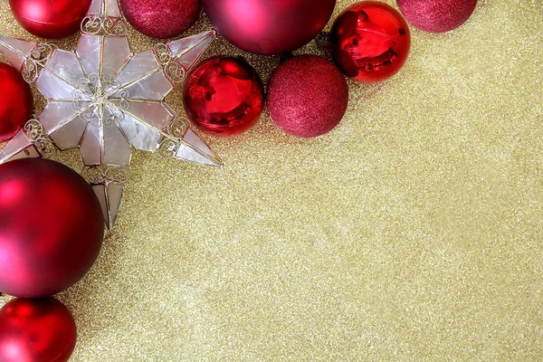 Weihnachtszwiebeln und Sternenschmuck auf goldenem Glitzerhintergrund — Stockfoto