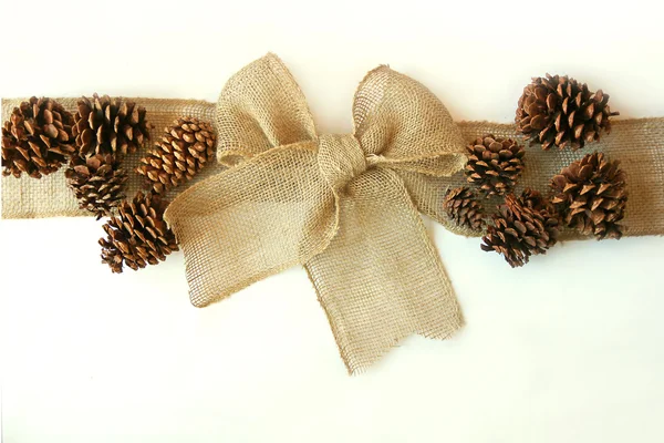 Arc de Noël en toile de jute avec des cônes de pin isolés sur fond blanc — Photo