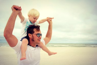 Baba oğulu Yong oynama ve sahilde yürüyüş