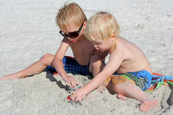 Duas crianças brincando de brinquedos na areia na praia — Fotografia de Stock