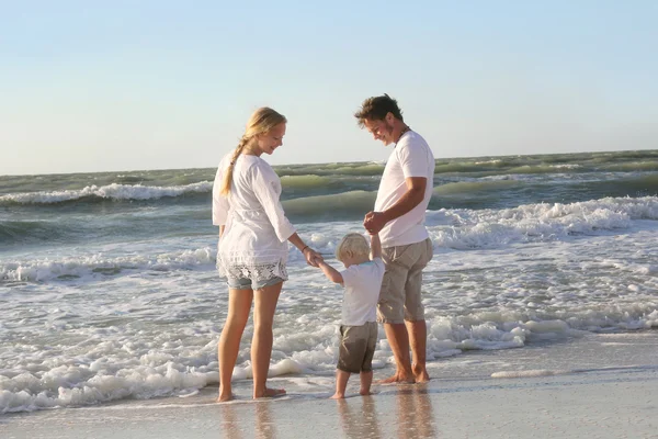 Família feliz de três pessoas brincando no oceano enquanto caminham Alon — Fotografia de Stock