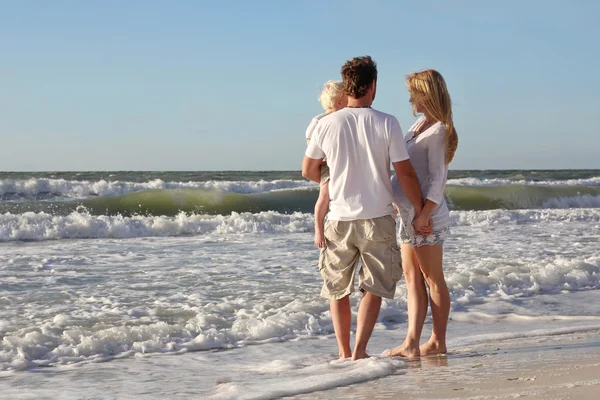 Familia feliz de tres personas jugando en el océano mientras caminan Alon —  Fotos de Stock