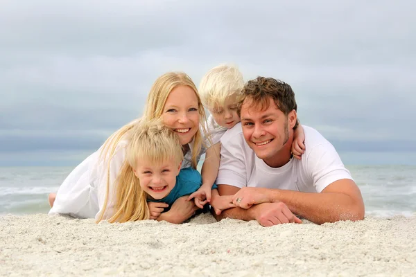 Retrato de família feliz de quatro pessoas relaxando na praia — Fotografia de Stock