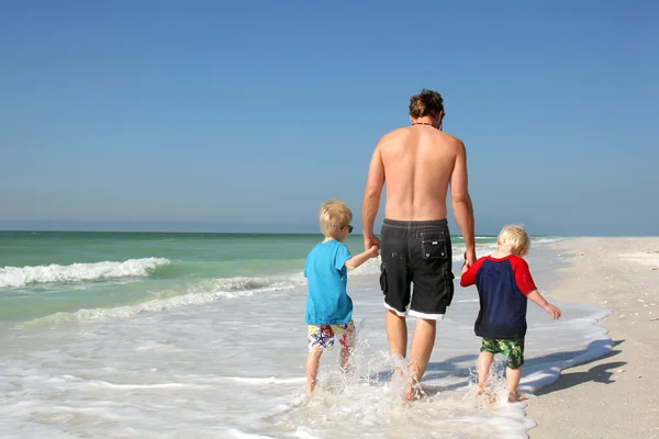 Padre e Hijos sosteniendo las manos caminando por el océano —  Fotos de Stock