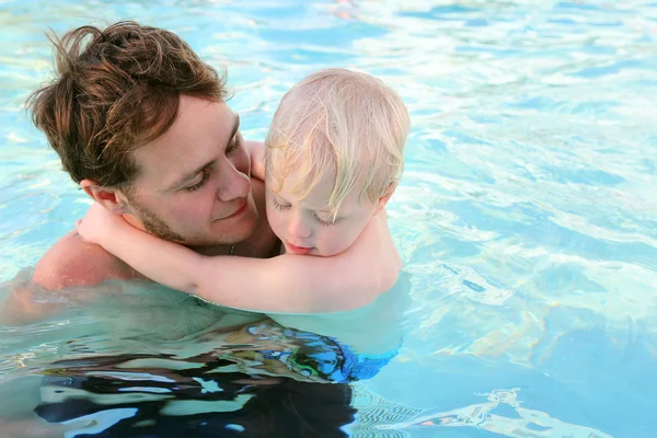 Padre llevando al niño a través del agua en la piscina — Foto de Stock