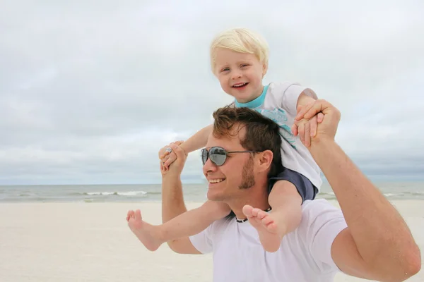 Pai e filho brincando na praia pelo oceano — Fotografia de Stock