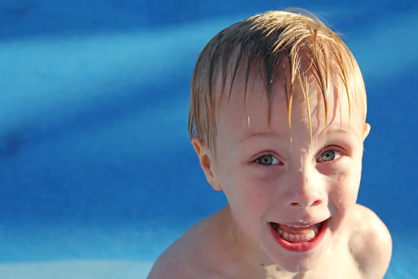 Criança fazendo rosto engraçado na piscina — Fotografia de Stock